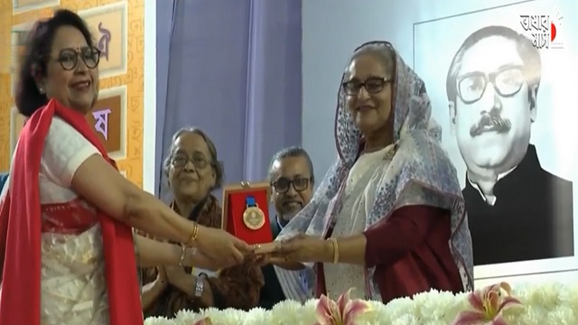 প্রধানমন্ত্রী শেখ হাসিনার কাছ থেকে বাংলা একাডেমি পুরস্কার নিচ্ছেন শামীম আজাদ। কবিতায় এই পুরস্কার পান তিনি।